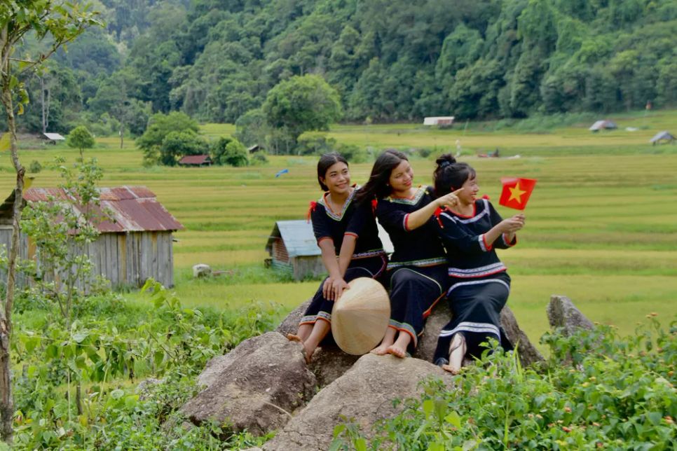 Bạn trẻ mang sắc phục non cao mang theo cờ tổ quốc chụp hình bên ruộng bậc thang Kon Tu Rằng
