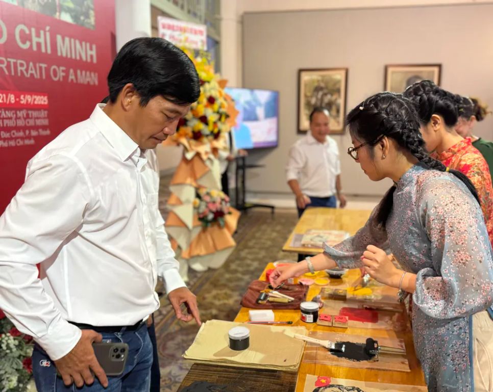 Khách tham quan trải nghiệm hoạt động in tranh khắc gỗ chân dung Chủ tịch Hồ Chí Minh