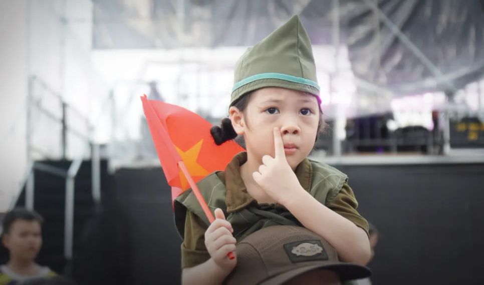 Bạn nhỏ cầm lá cờ Tổ quốc với đồng phục rất dễ thương tại lễ hội đường phố ở Quy Nhơn