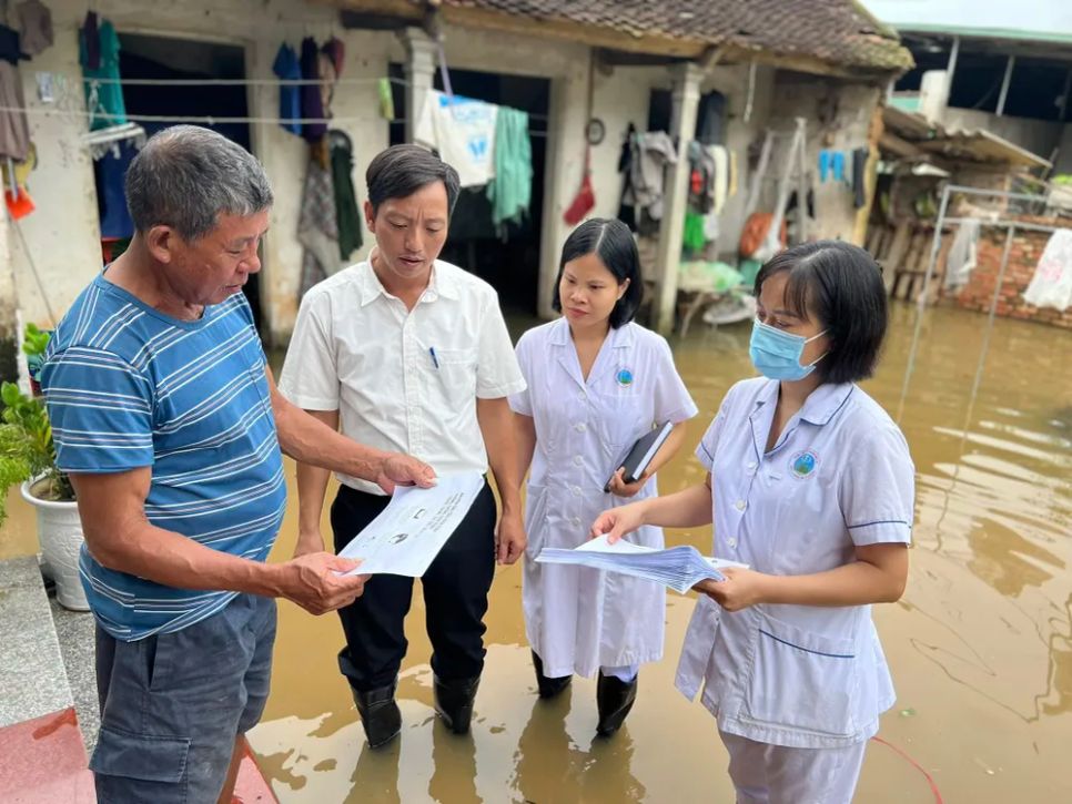 Cán bộ y tế cơ sở ở Quốc Oai, Hà Nội tuyên truyền phòng chống dịch bệnh cho người dân vùng lũ