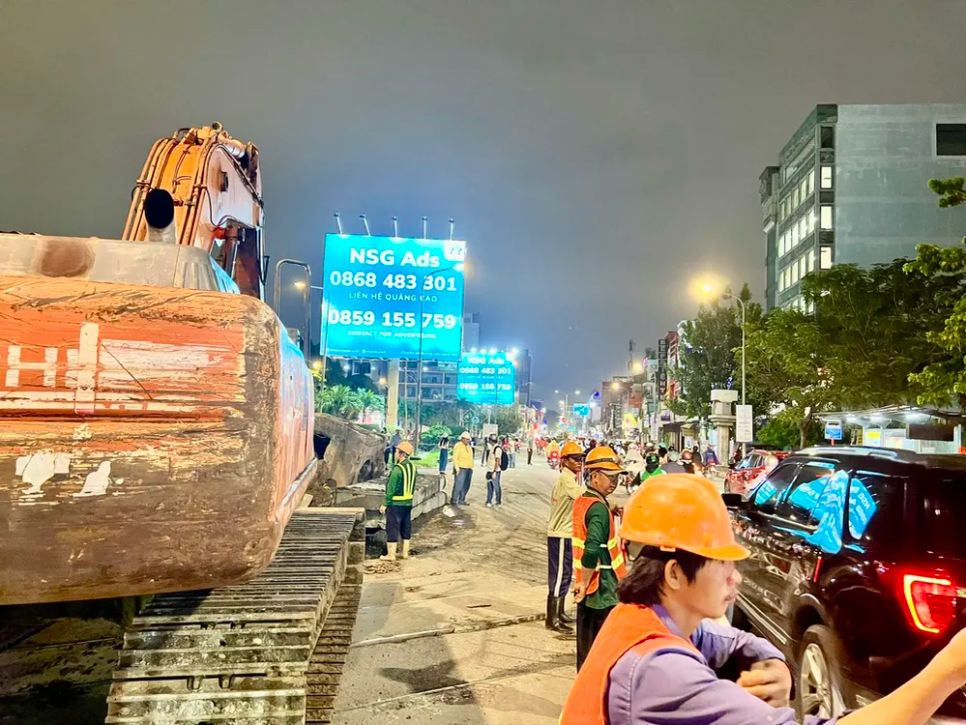 Vừa thi công vừa điều tiết phương tiện lưu thông trên đường. Ảnh: QUỐC HÙNG