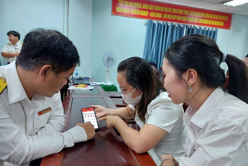 Ông Trần Minh Nhã hướng dẫn hộ kinh doanh cài đặt, sử dụng eTax Mobile. Ảnh: MAI HOA Ông Trần Minh Nhã hướng dẫn hộ kinh doanh cài đặt, sử dụng eTax Mobile. Ảnh: MAI HOA