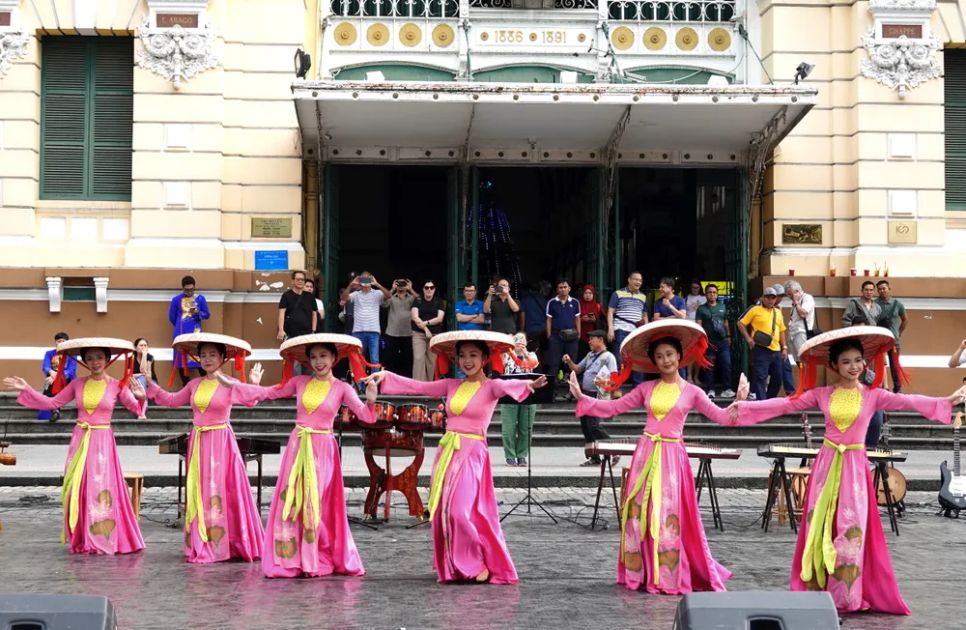 Sau khi tham quan Bưu điện Thành phố, du khách quốc tế rất thích thú khi được thưởng thức những tiết mục biểu diễn nghệ thuật truyền thống dân tộc Việt Nam. Ảnh: THÚY BÌNH