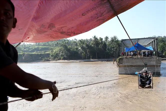 Người dân tìm cách qua sông bằng hệ thống dây kéo khi cây cầu bị phá huỷ do mưa lũ tại tỉnh Aceh, Indonesia ngày 1-12. Ảnh: THX/TTXVN Người dân tìm cách qua sông bằng hệ thống dây kéo khi cây cầu bị phá huỷ do mưa lũ tại tỉnh Aceh, Indonesia ngày 1-12. Ảnh: THX/TTXVN