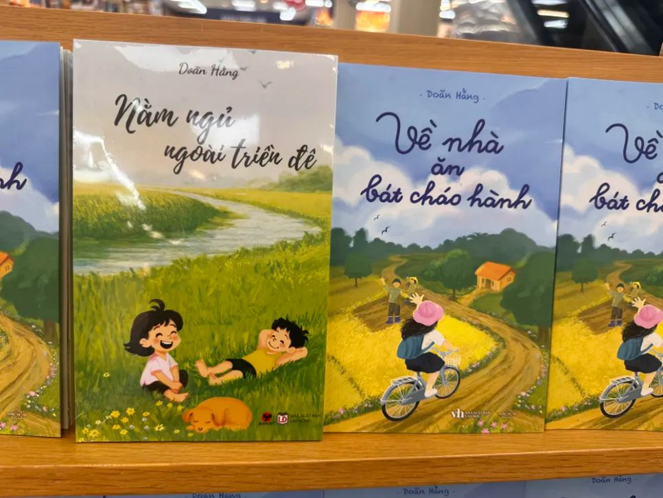 Hai tác phẩm của tác giả Doãn Hằng: Nằm ngủ ngoài triền đê (truyện dài) và Về nhà ăn bát cháo hành (tản văn). Ảnh: QUỲNH YÊN Hai tác phẩm của tác giả Doãn Hằng: Nằm ngủ ngoài triền đê (truyện dài) và Về nhà ăn bát cháo hành (tản văn). Ảnh: QUỲNH YÊN