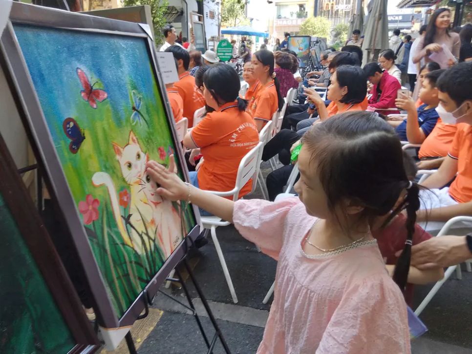 Một bạn nhỏ thích thú xem tranh tại triển lãm Một bạn nhỏ thích thú xem tranh tại triển lãm