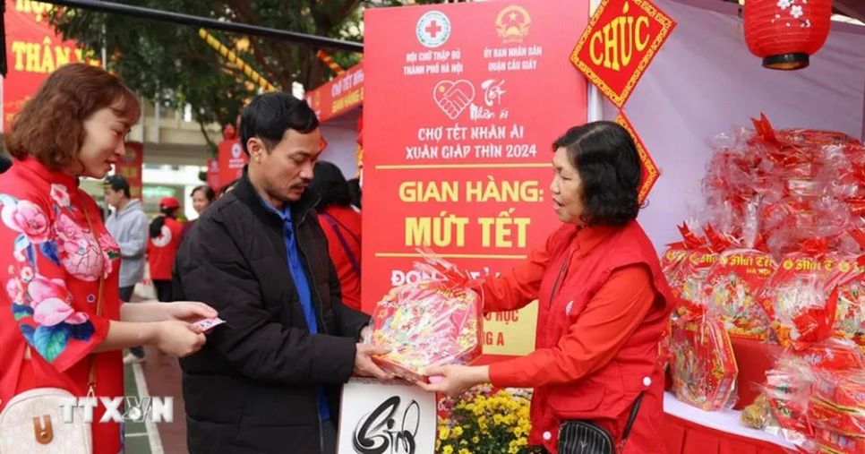 Người dân đổi phiếu để nhận hàng miễn phí tại các gian hàng ở Chợ Tết nhân ái Hà Nội. (Ảnh: Thanh Tùng/TTXVN) Người dân đổi phiếu để nhận hàng miễn phí tại các gian hàng ở Chợ Tết nhân ái Hà Nội. (Ảnh: Thanh Tùng/TTXVN)