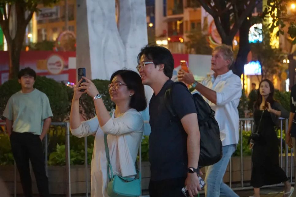 Du khách nước ngoài quay lại hình ảnh bắn pháo hoa tại phố đi bộ Nguyễn Huệ, TPHCM. Ảnh: DŨNG PHƯƠNG
