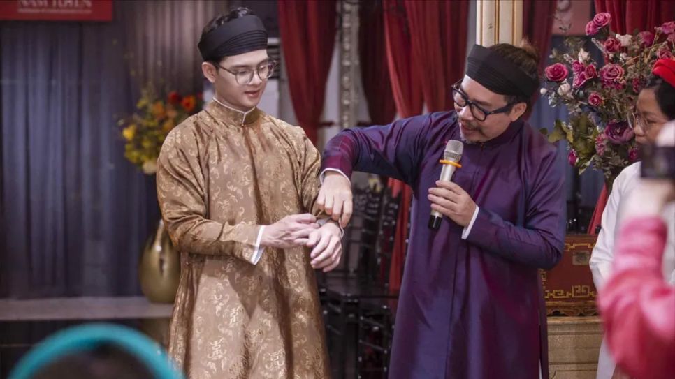 Nghệ nhân Năm Tuyền giới thiệu từng chi tiết trên áo dài ngũ thân. Ảnh: Phạm Hoàn