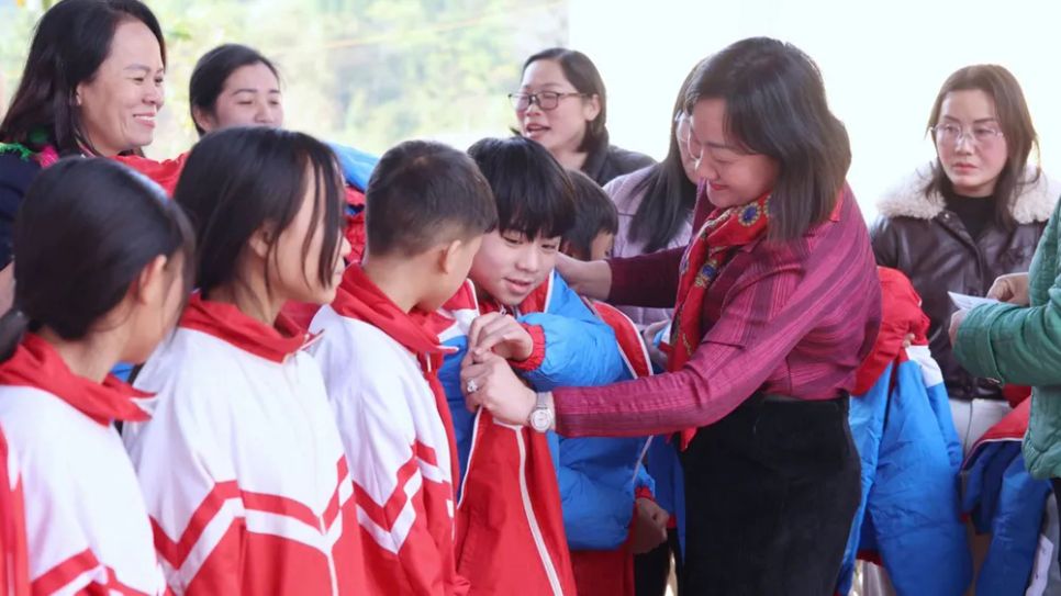 Phó Tổng Biên tập Báo SGGP Bùi Thị Hồng Sương trao áo ấm cho học sinh Trường Phổ thông dân tộc Bán trú THCS Lương Thông (ẢNH: QUANG PHÚC)