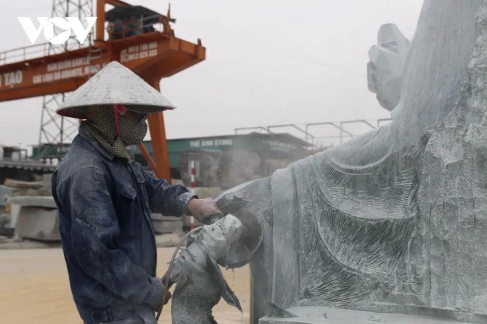 <p>Nữ nghệ nhân đứng vững bên khối đá, tay cầm máy mài, cắt từng đường dứt khoát mà mềm mại. Tia bụi trắng bay lên, dáng tượng Quan Âm dần hiện rõ, toát lên vẻ từ bi, thanh khiết qua từng nét tạo tác tỉ mỉ. Đó là chị Nguyễn Thị Nga, 53 tuổi, sinh ra và lớn lên trên mảnh đất này. Chị theo nghề từ khi mới học xong cấp 2. Ngày ấy, tất cả đều làm thủ công, chưa có máy móc hỗ trợ. Vợ chồng chị từng phải dùng xe bò chở đá từ chân núi ra bờ sông, chuyển xuống thuyền, để họ chở đi khắp nơi bán. Khoảng 20 năm trở lại đây, chị đi làm cho các công ty sản xuất đá mỹ nghệ trên địa bàn nên cuộc sống dần đổi khác. Kinh tế khá hơn, con cái được học đại học, lập gia đình và có cuộc sống gia đình ổn định.</p>