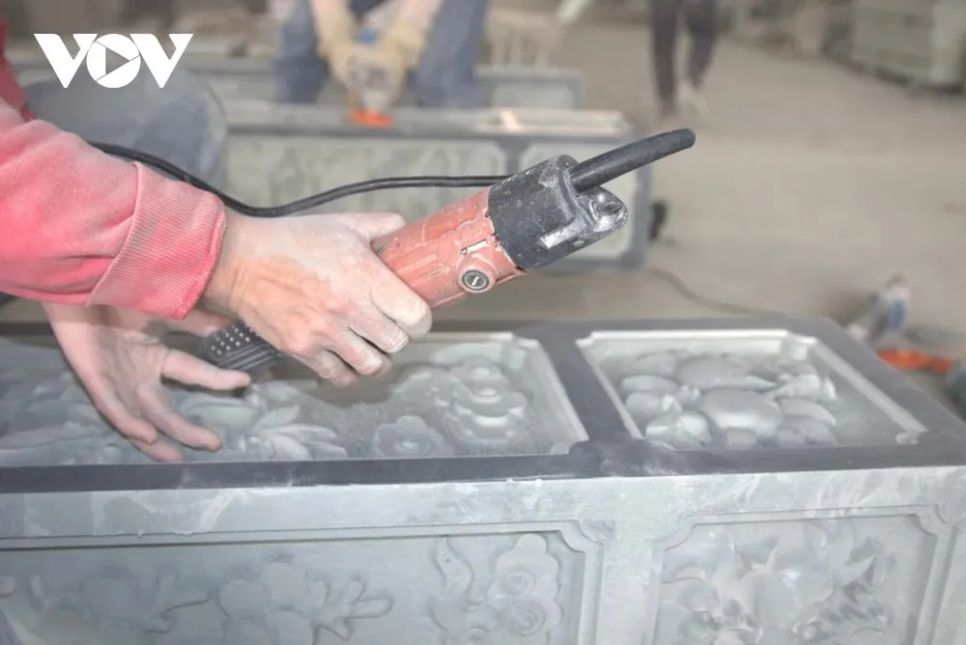 <p>Trong xưởng đá phủ đầy bụi trắng, từng đường nét chạm khắc được thực hiện khẩn trương nhưng chính xác đến từng li. Người thợ chăm chú dõi theo mũi đục, điều chỉnh lực tay vừa đủ, để hoa văn mềm mại mà không làm sứt mẻ cấu trúc đá, giữ trọn hồn cốt của sản phẩm thủ công truyền thống.</p>