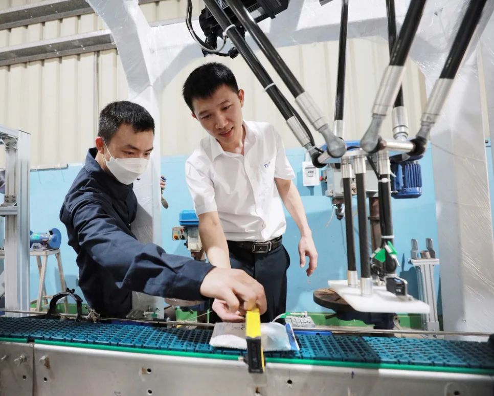 Anh Thái Bình Dương (áo trắng) cùng đồng nghiệp kiểm tra các dây chuyền tại Nhà máy chế biến sữa tươi sạch TH true MILK