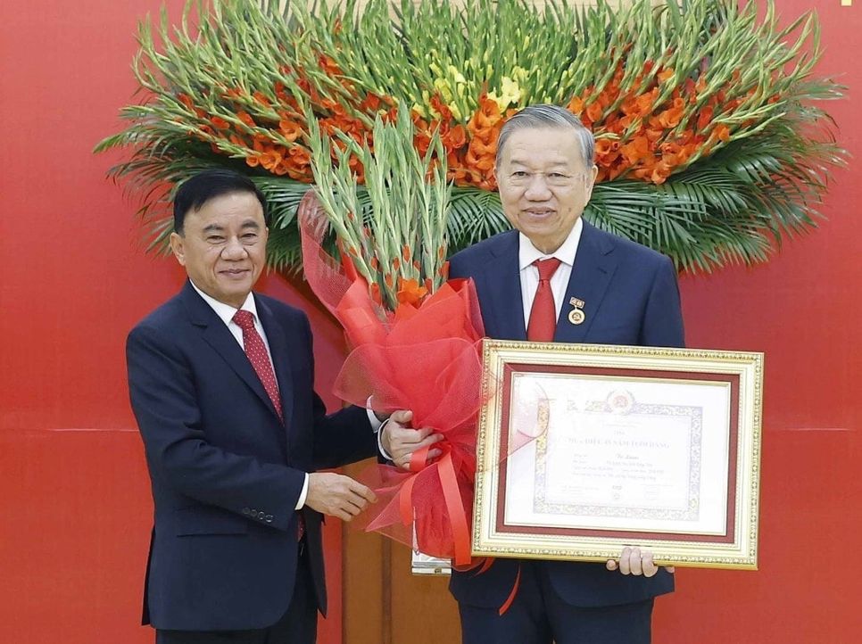 Ủy viên Bộ Chính trị, Thường trực Ban Bí thư Trần Cẩm Tú trao Huy hiệu Đảng và tặng hoa chúc mừng Tổng Bí thư Tô Lâm. Ảnh: TTXVN