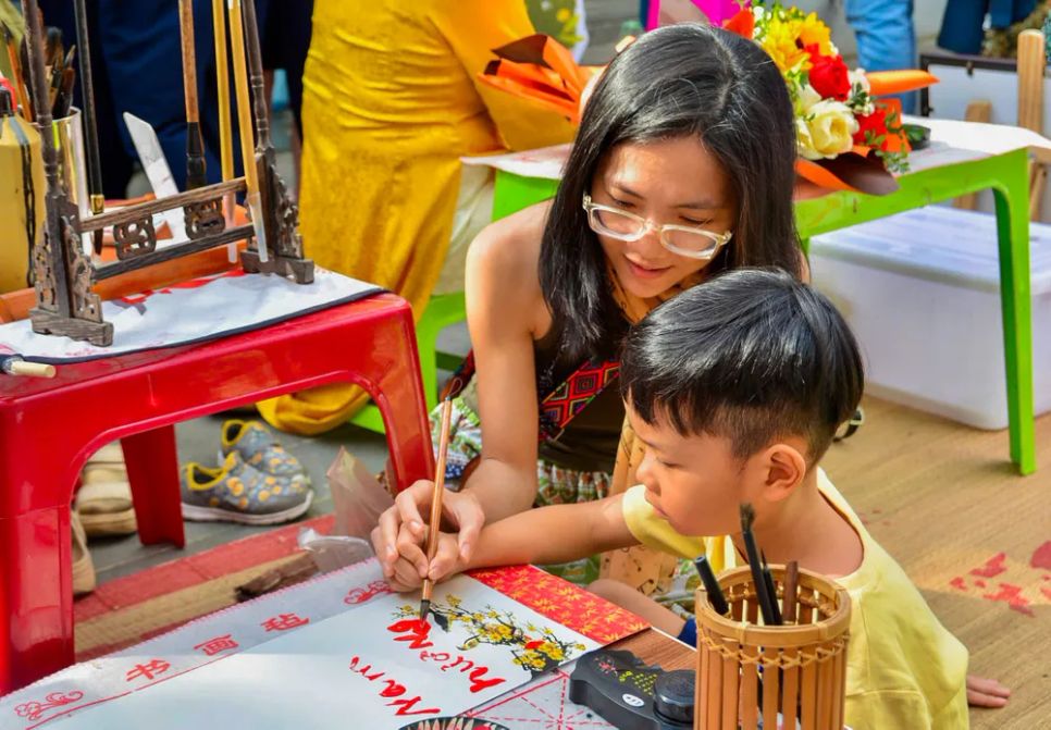 Các em trải nghiệm viết chữ tại sự kiện “Rước mã khai xuân”. Ảnh: THANH ÁI