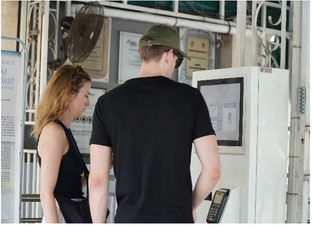 Du khách nước ngoài trải nghiệm mua vé điện tử.