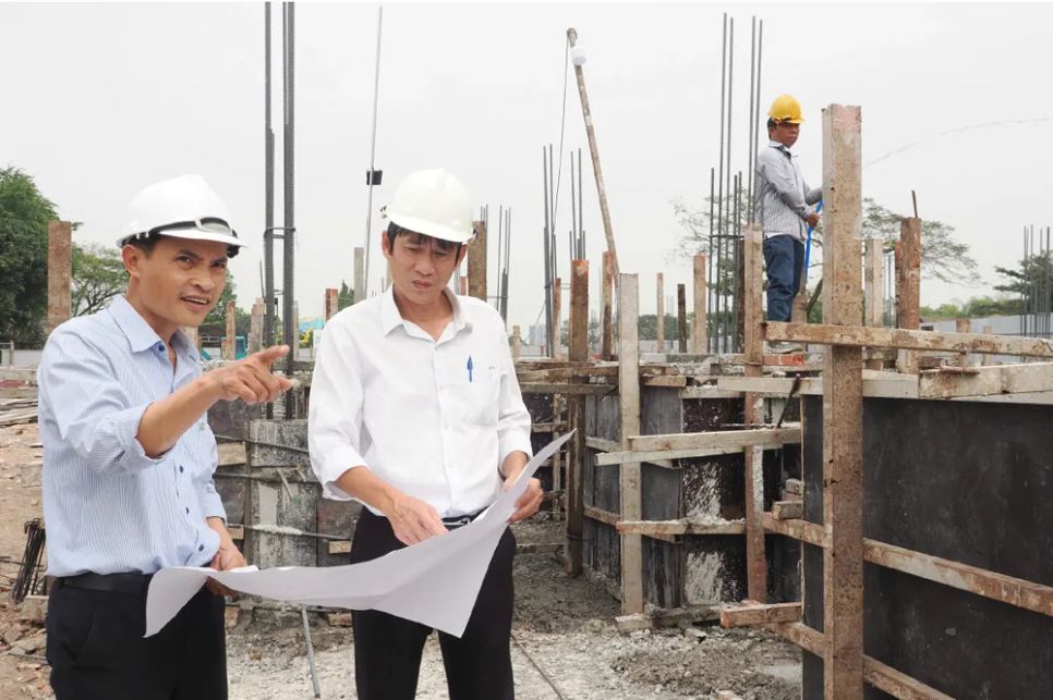 Phó Giám đốc BQL dự án đầu tư xây dựng khu vực Bình Tân (áo trắng) kiểm tra dự án Trường THCS Bình Hưng Hoà. Ảnh: HOÀNG HÙNG