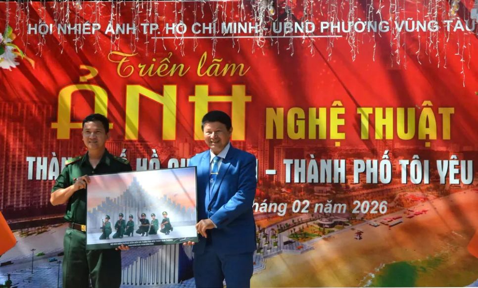 Đại tá - nghệ sĩ nhiếp ảnh Đoàn Hoài Trung, Chủ tịch Hội nhiếp ảnh TPHCM (bên phải) trao tặng ảnh cho các đơn vị biên phòng. Ảnh: QUANG VŨ