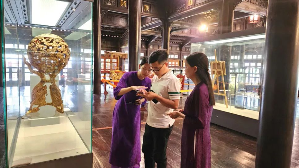 Du khách tham quan, tìm hiểu cổ vật trưng bày tại Bảo tàng cổ vật cung đình Huế có gắn chip NFC