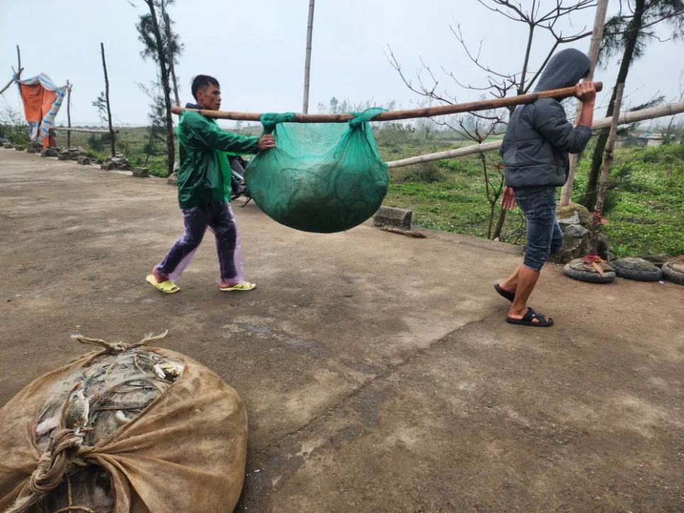 Ngư dân gánh lưới chứa ghẹ và cá lên tuyến đê biển để gỡ bán cho khách hàng