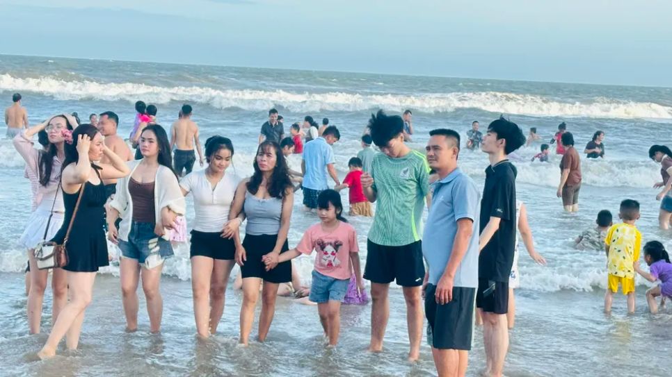 Khách chụp hình lưu niệm tại biển Bãi Sau chiều mùng 3 Tết. Ảnh: QUANG VŨ