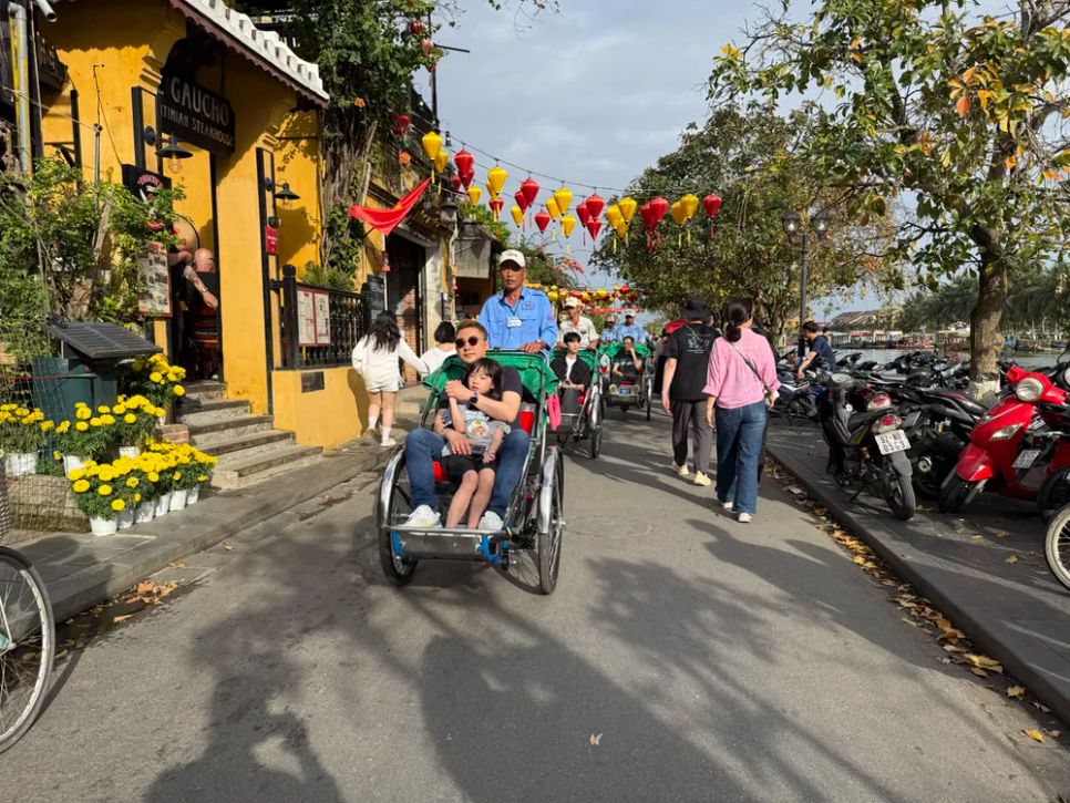 Du khách quốc tế tham quan phố cổ bằng xe xích lô. Ảnh: NGUYỄN CƯỜNG