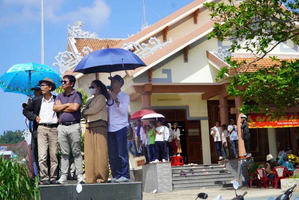 Người dân tận dụng những vị trí cao trong nhà để xem đua thuyền. Ảnh: NGUYỄN TRANG