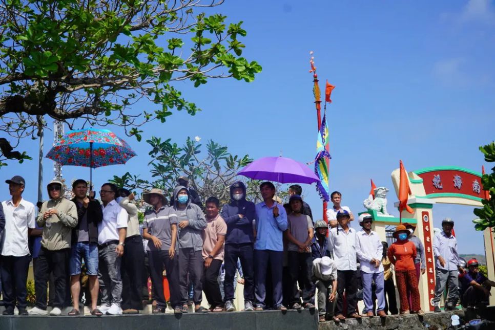 Người dân theo dõi trận đua thuyền dưới cái nắng trên đặc khu Lý Sơn. Ảnh: NGUYỄN TRANG