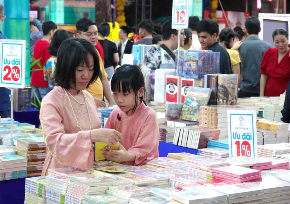 Mẹ chọn sách hay cho con trong ngày đầu năm mới. Ảnh: THÚY BÌNH