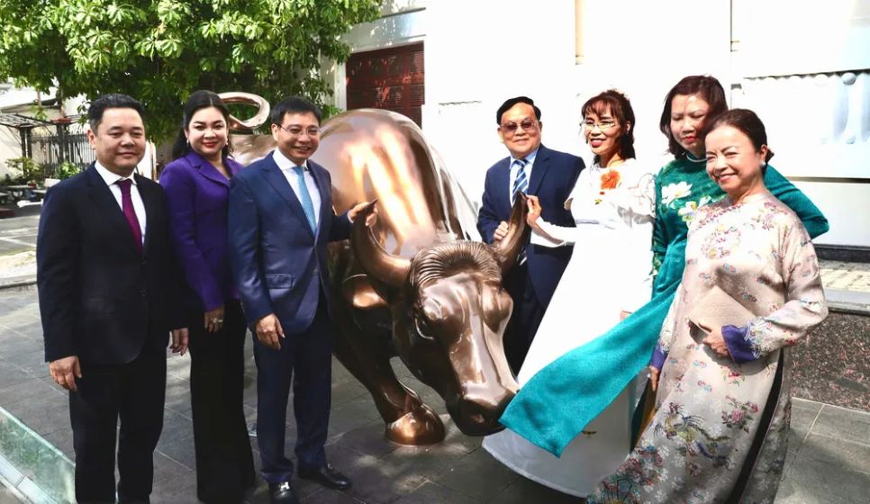 Lãnh đạo Bộ Tài chính, Ủy ban Chứng khoán Nhà nước và đại diện các doanh nghiệp chụp hình cùng linh vật biểu tượng của thị trường chứng khoán trước cổng HOSE. Ảnh: HẠNH NHUNG