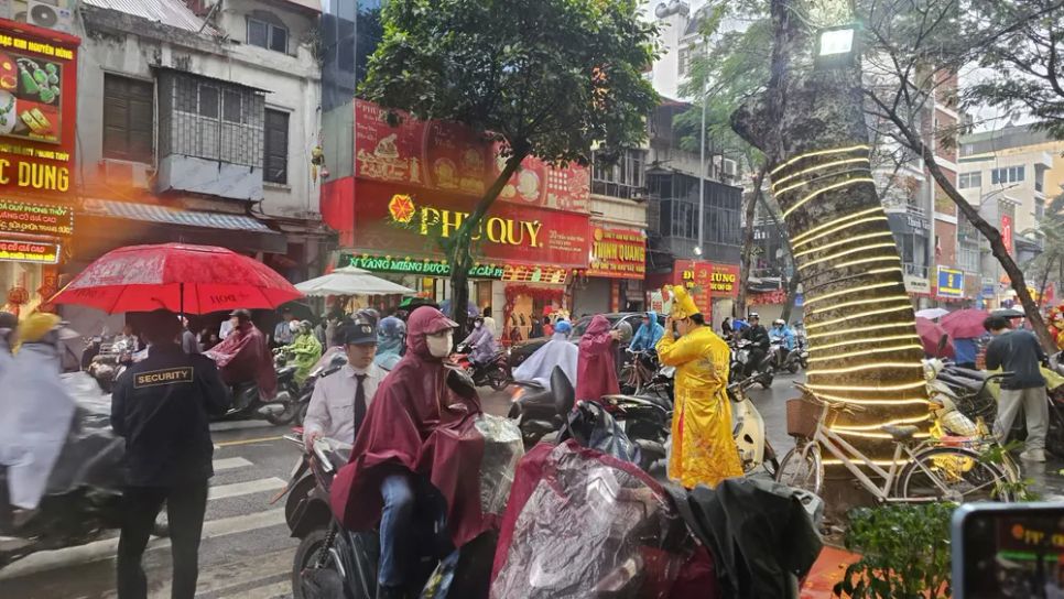 Người dân chờ mua vàng bất chấp trời Hà Nội sáng nay mưa. Ảnh: LƯU THỦY