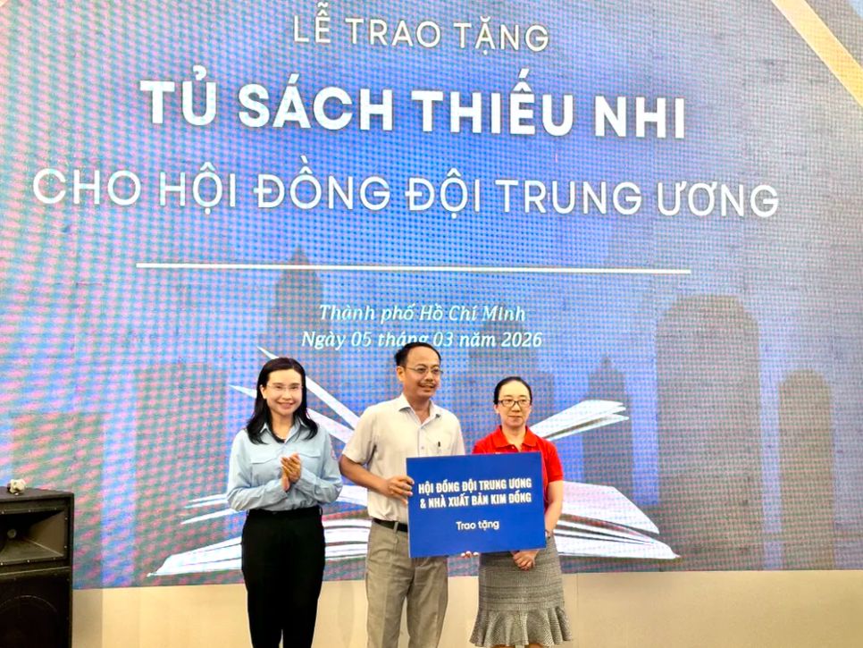 Nhà văn Phan Hồn Nhiên (phải) đại diện NXB Kim Đồng trao tặng sách cho Làng thiếu niên Thủ Đức. Ảnh: QUỲNH YÊN