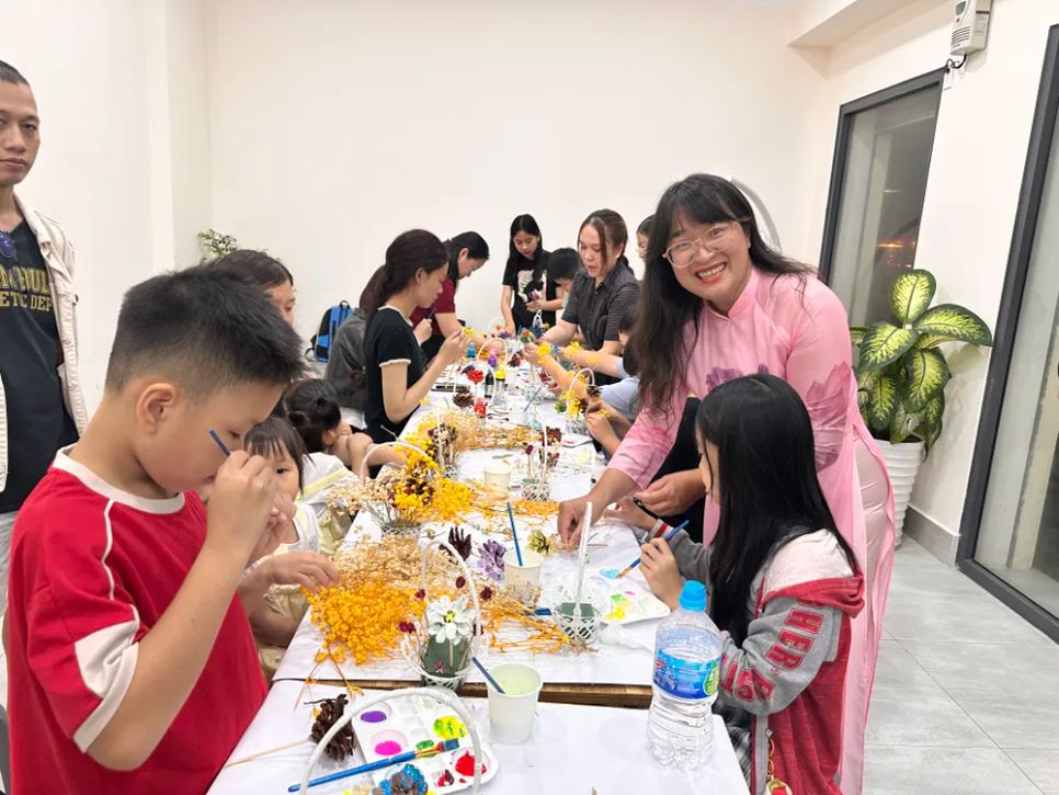 Tác giả Thanh Tâm hướng dẫn các em nhỏ làm giỏ hoa tặng mẹ nhân ngày Quốc tế Phụ nữ 8-3 trước khi diễn ra chương trình giao lưu