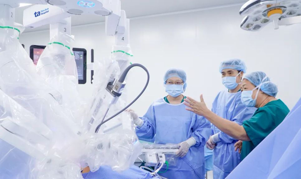 BS-CK2 Nguyễn Bá Mỹ Nhi, Giám đốc Trung tâm Sản Phụ khoa, Bệnh viện Đa khoa Tâm Anh TPHCM (ngoài cùng bìa phải) hướng dẫn êkíp bác sĩ trước khi phẫu thuật bằng robot Da Vinci Xi.