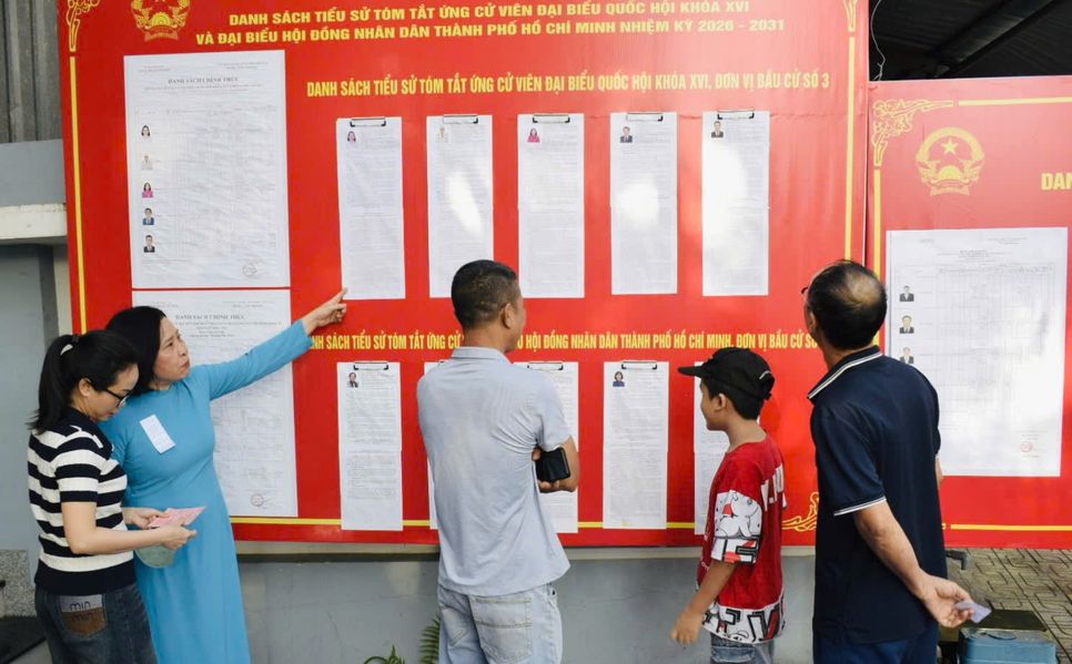 Cán bộ hướng dẫn cử tri cách ghi phiếu bầu hợp lệ tại khu phố Đông Tân phường Dĩ An