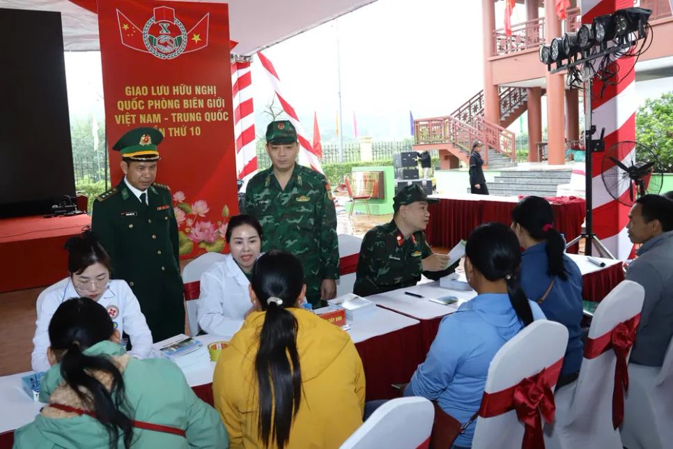 Lực lượng chức năng hướng dẫn người dân làm thủ tục khám bệnh. Ảnh: BQP