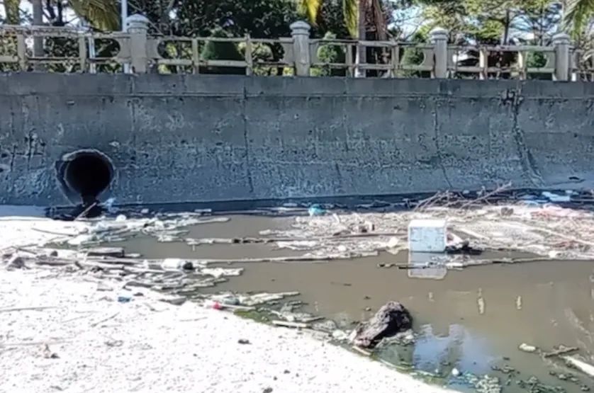 Dòng nước thải chưa qua xử lý chảy ra từ cửa xả thấm xuống bãi cát. Ảnh: NDCC