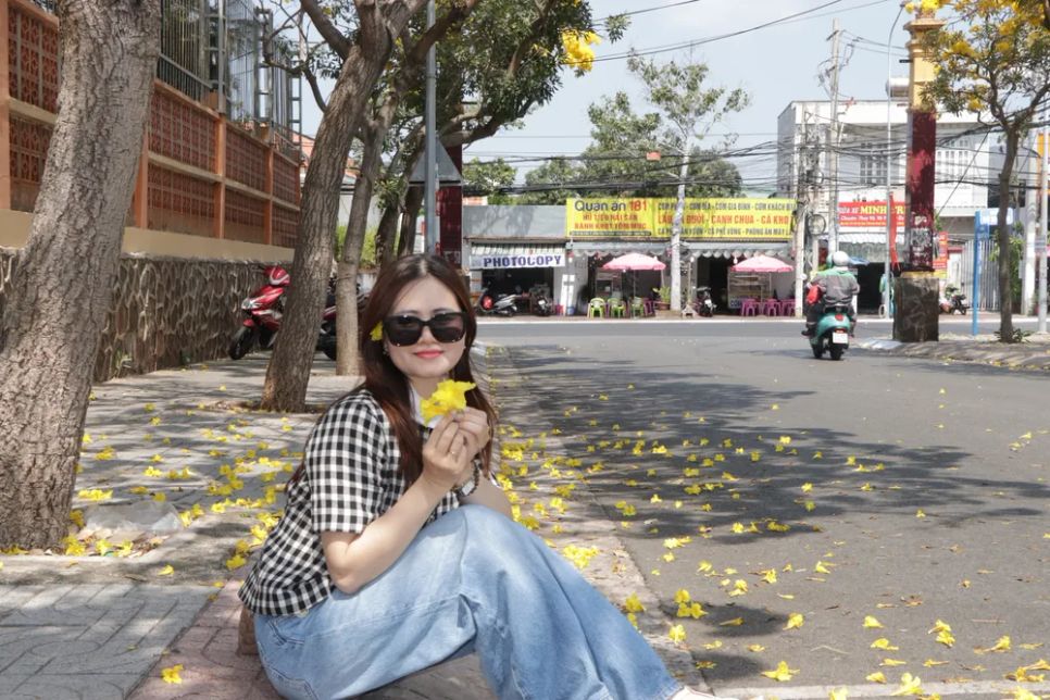 Một bạn trẻ tạo dáng chụp hình với hoa chuông vàng. Ảnh: QUANG VŨ