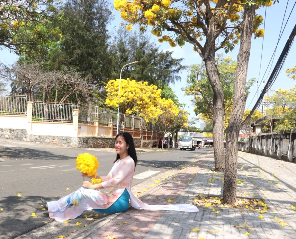 Một số bạn gái diện áo dài để chụp ảnh với hoa chuông vàng. Ảnh: QUANG VŨ