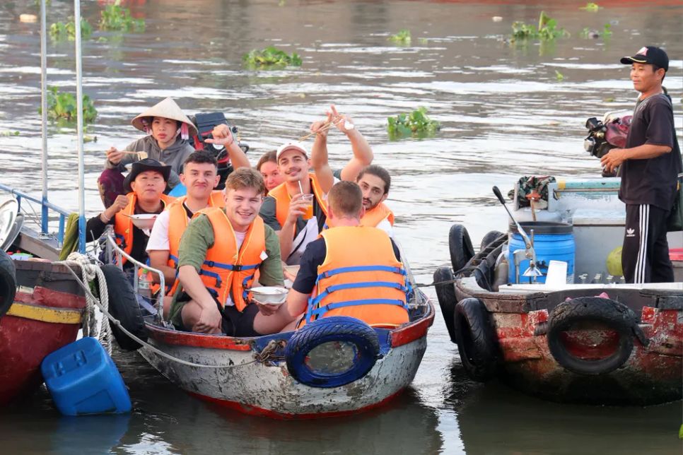 Du khách nước ngoài hào hứng khi trải nghiệm đi thuyền trên sông nước Chợ nổi Cái Răng (TP Cần Thơ)