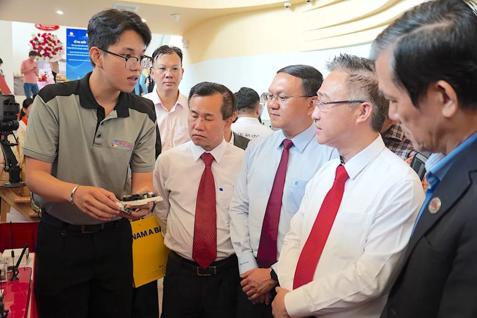 <p> Đồng chí Đặng Minh Thông (thứ 2 từ phải sang) nghe đại diện Trường Đại học Kỹ thuật công nghệ giới thiệu về chip thiết kế vi mạch do trường nghiên cứu, sáng chế. ẢNH QUANG HUY </p>