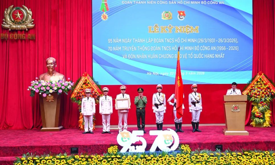 Bộ trưởng Bộ Công an Lương Tam Quang gắn Huân chương Bảo vệ Tổ quốc hạng Nhất lên cờ truyền thống và trao Bằng Huân chương Bảo vệ Tổ quốc hạng nhất tặng Đoàn TNCS Hồ Chí Minh Bộ Công an. Ảnh: HỒNG DŨNG