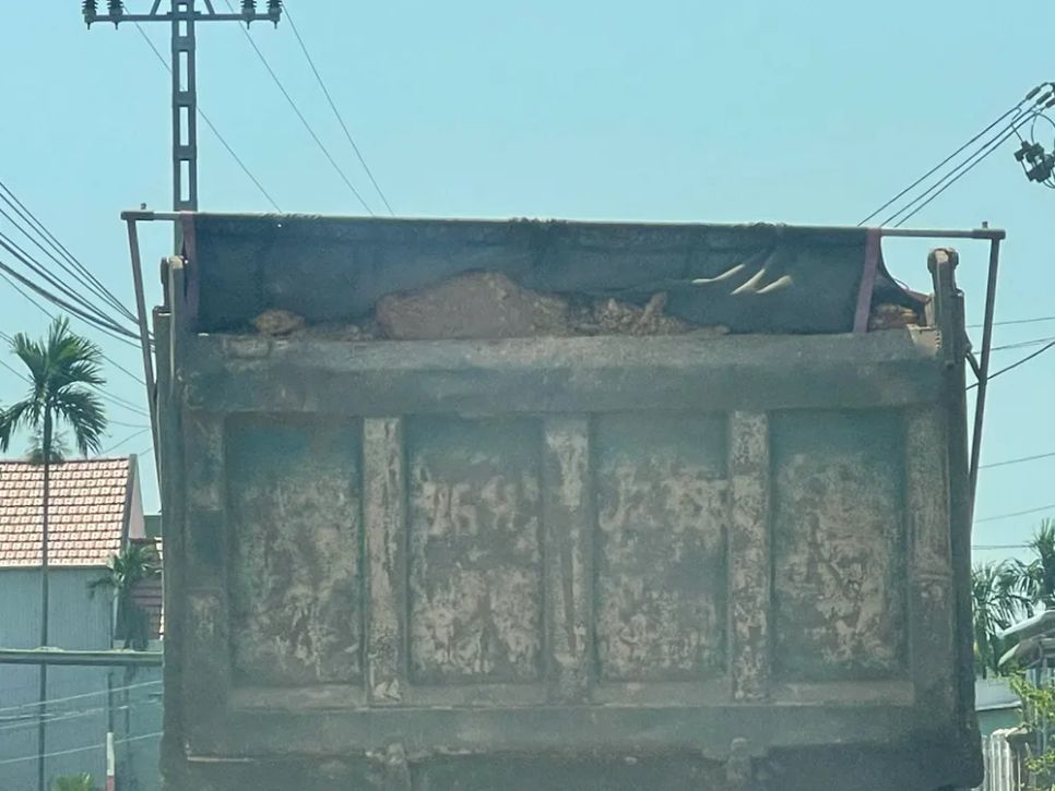 Đất trên thùng xe tải không được che chắn kỹ khiến rơi vãi xuống đường, ô nhiễm môi trường