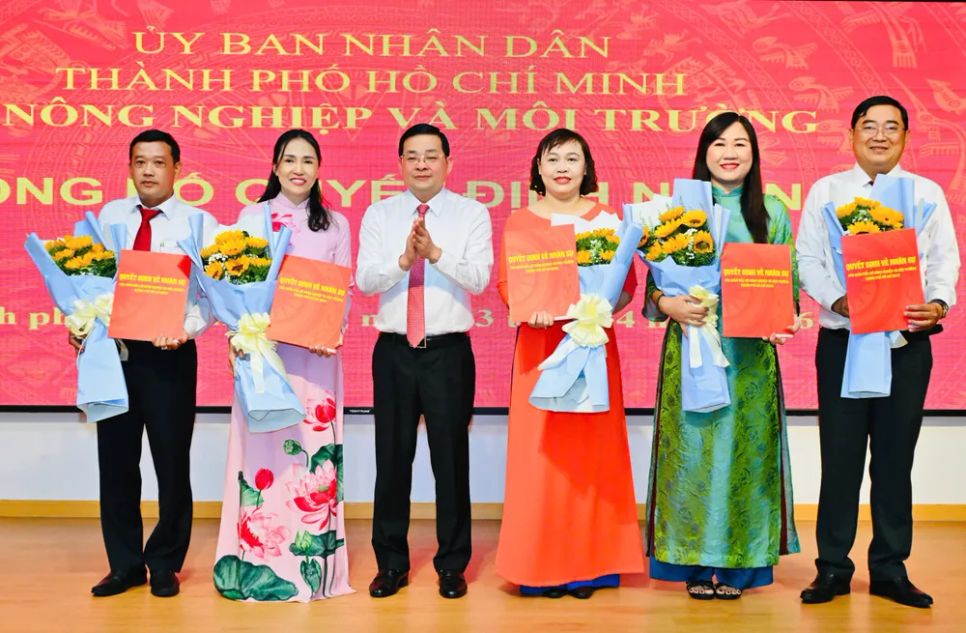 Giám đốc Nguyễn Toàn Thắng trao quyết định và tặng hoa chúc mừng cho cán bộ thuộc hệ thống VPĐKĐĐ TPHCM. Ảnh: Việt Dũng