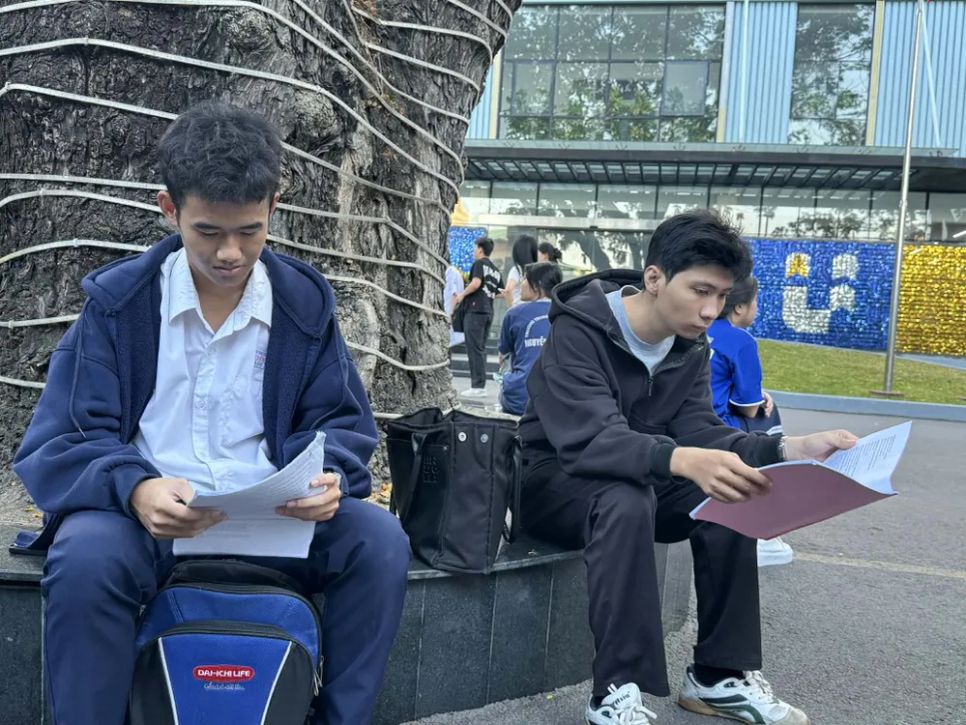 Thí sinh đến điểm thi sớm và tranh thủ ôn bài - Ảnh: THANH HÙNG