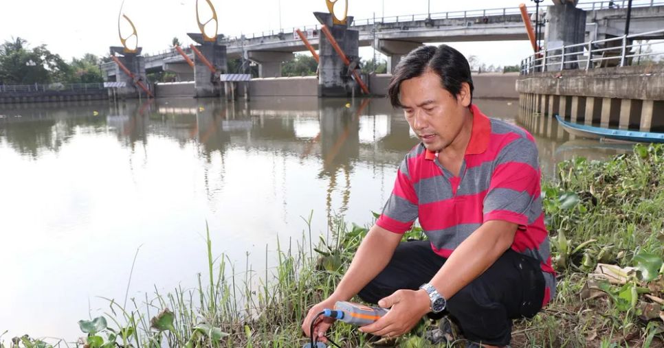 Đo độ mặn bên trong cống Bông Bót (xã An Phú Tân, Vĩnh Long) để đóng, mở cống phù hợp. (Ảnh: Thanh Hòa/TTXVN)