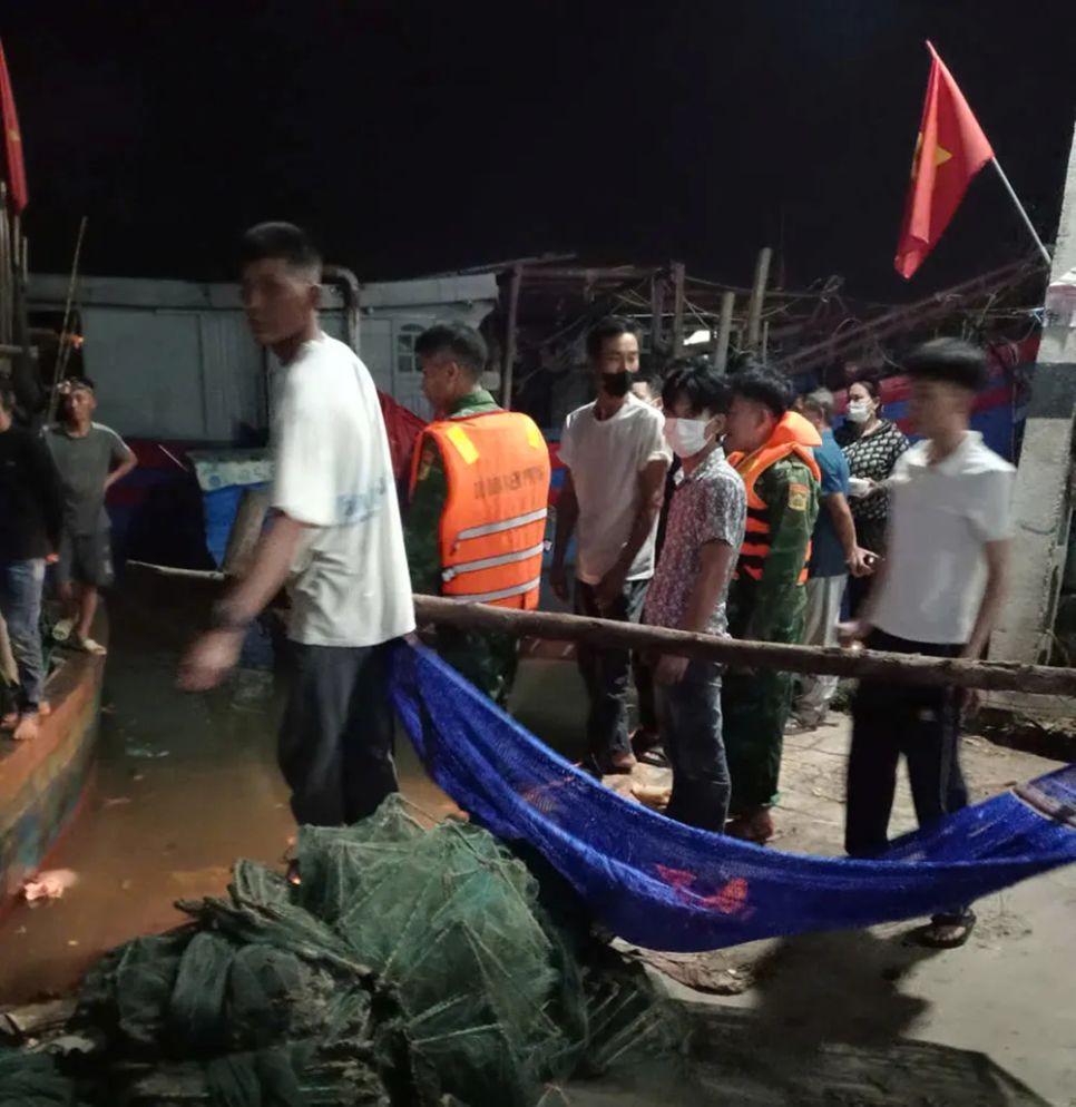 Lực lượng chức năng và người dân đưa thi thể anh T.V.D. vào bờ, bàn giao cho gia đình