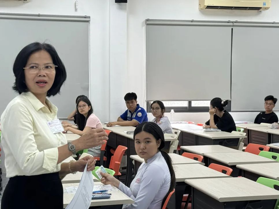 Cán bộ coi thi kiểm tra thông tin thí sinh tại điểm thi Trường ĐH Công nghiệp TPHCM - Ảnh: THANH HÙNG