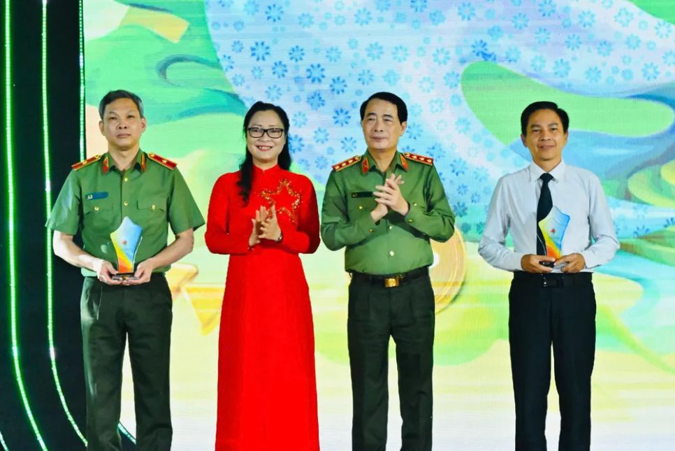 Thượng tướng Lê Quốc Hùng trao biểu trưng cuộc thi cho đại diện Công an TPHCM và đại diện Sở GD-ĐT TPHCM. Ảnh: VIỆT DŨNG