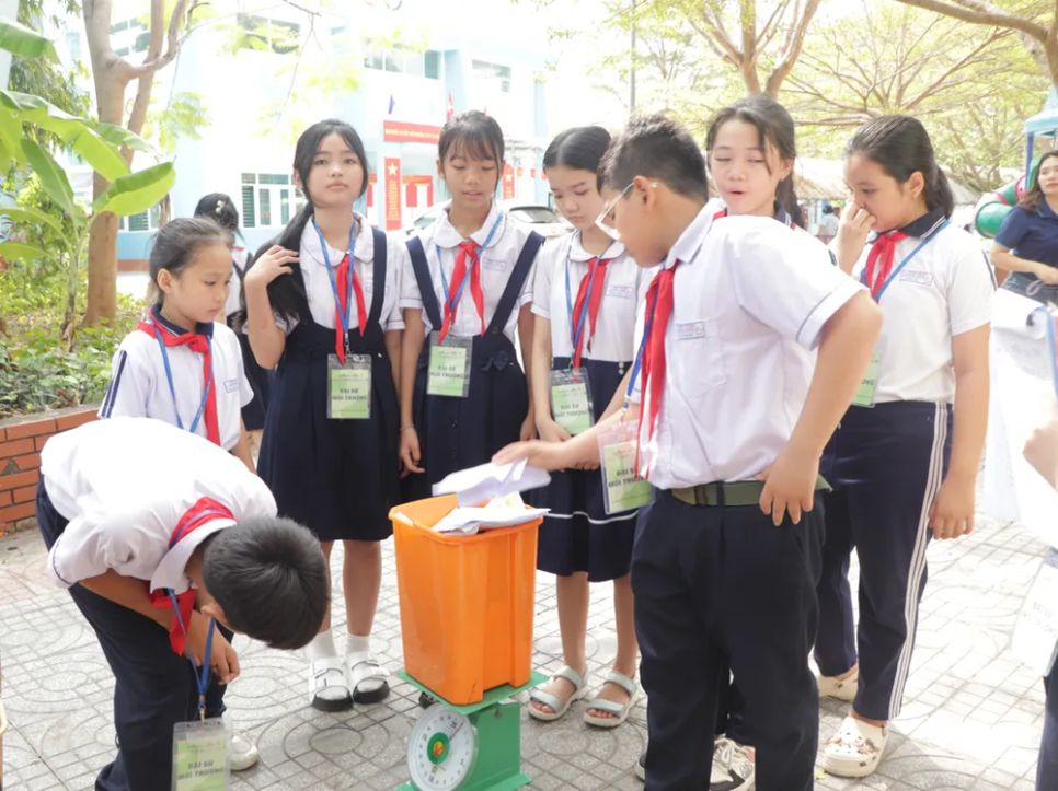 Học sinh Trường Tiểu học Long Sơn 2 (xã Long Sơn, TPHCM) cân ký rác tái chế sau khi phân loại. Ảnh: SONG THƯ